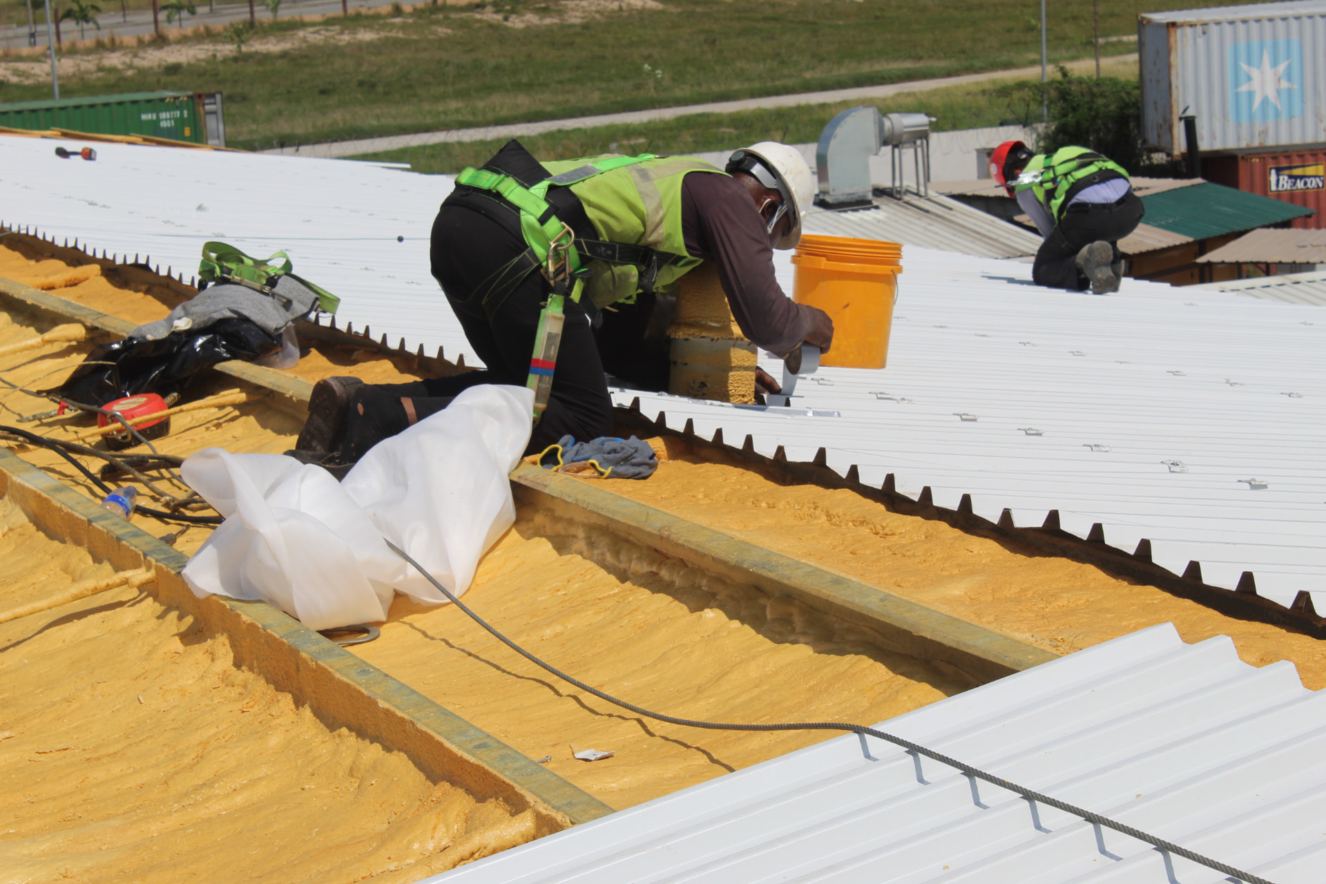 Technicians installing insulated roof sheeting