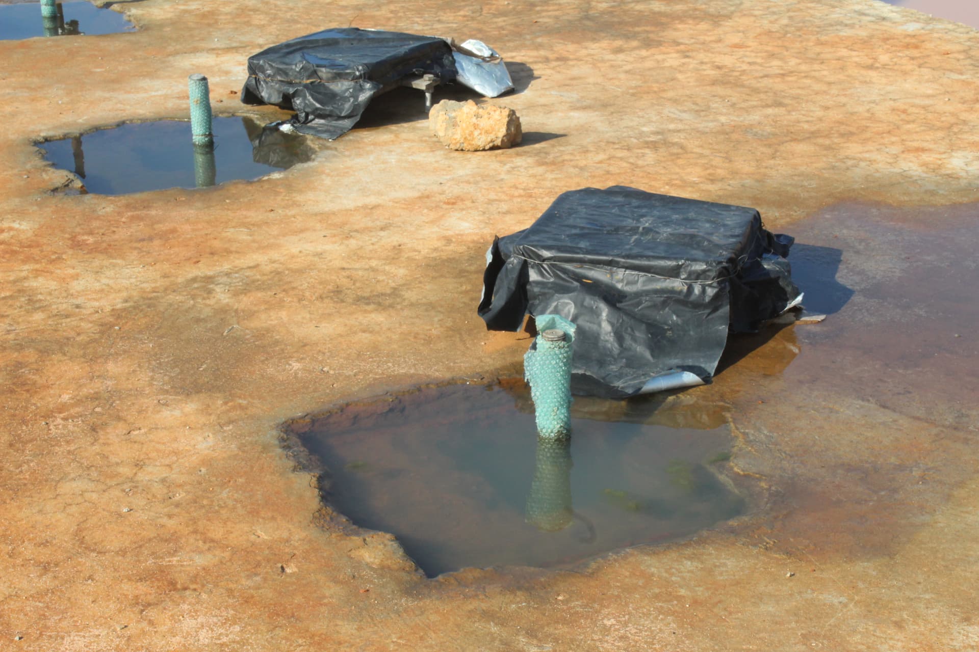 Grouted base plates protected with sheeting during curing