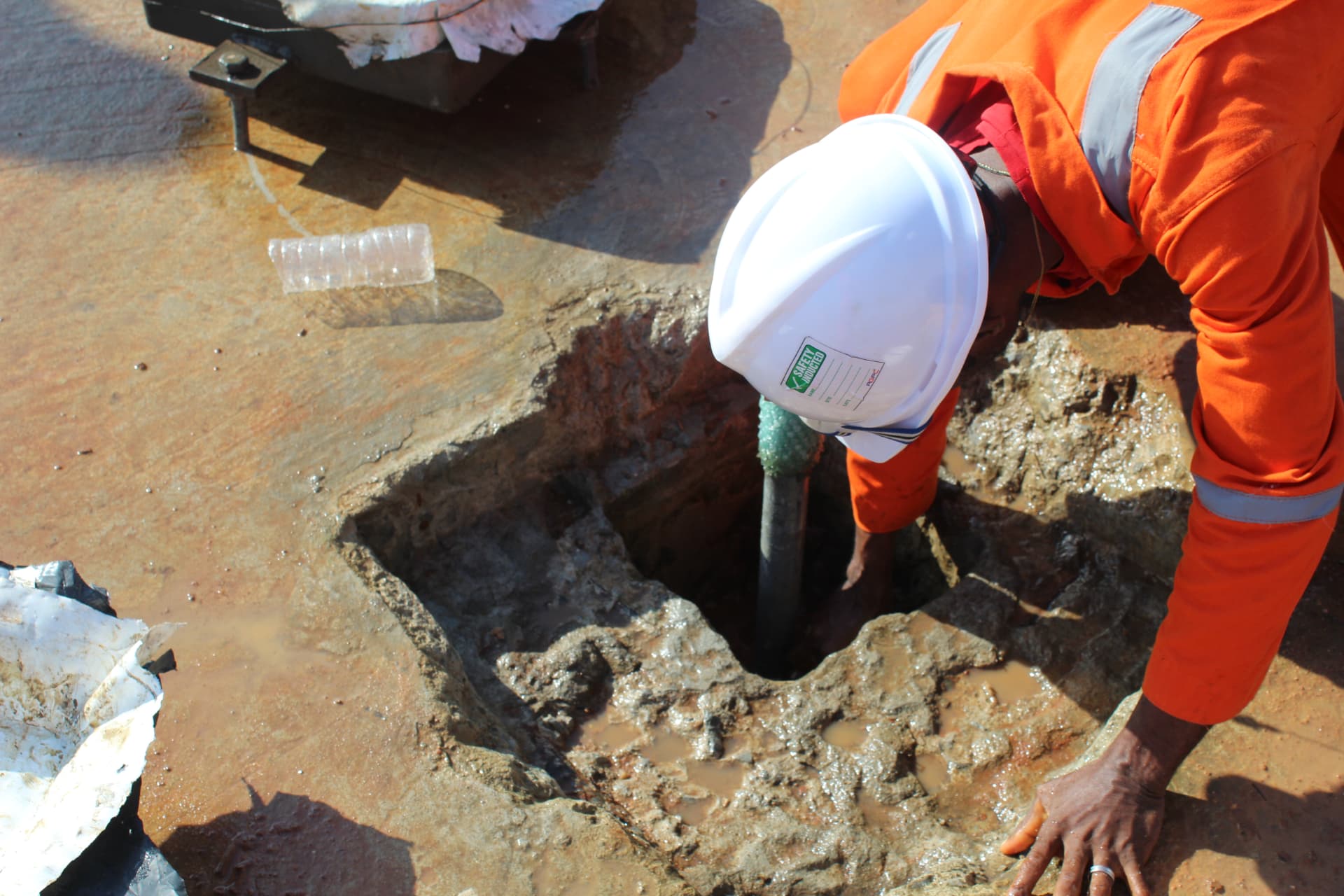 Operative inspecting a prepared anchor bolt pocket before grouting