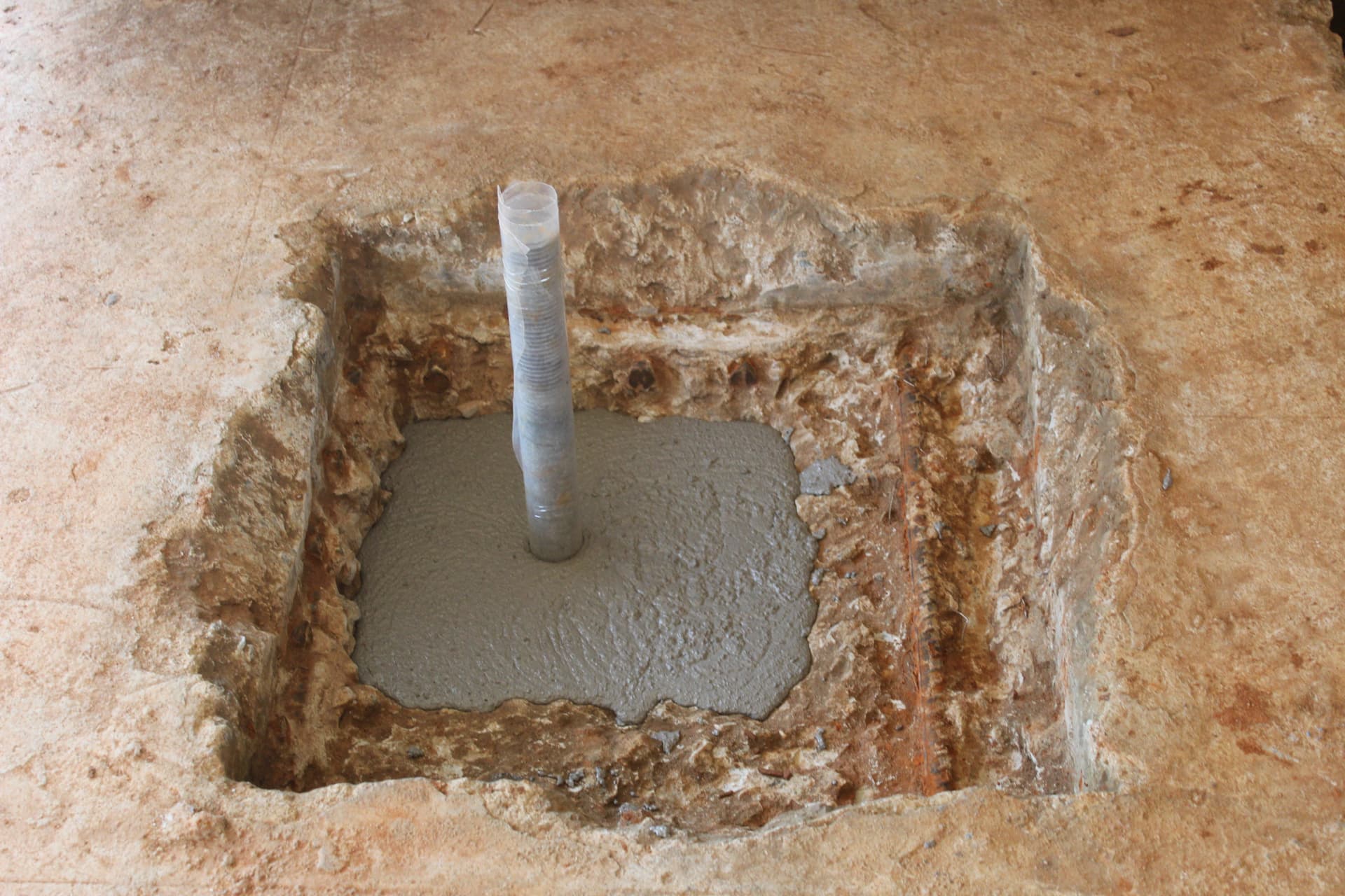 Completed grout pour around an anchor bolt in a foundation pocket