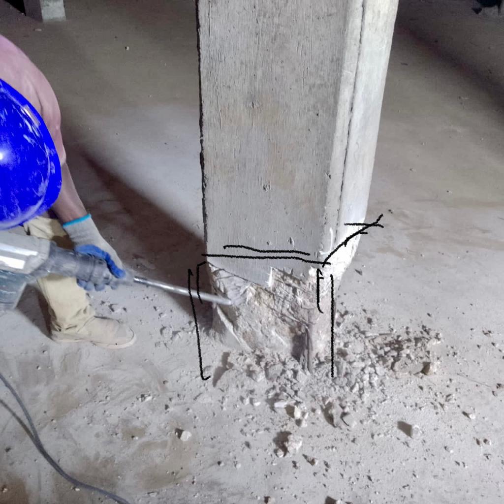 Marked-out repair zone being chipped back at a column base