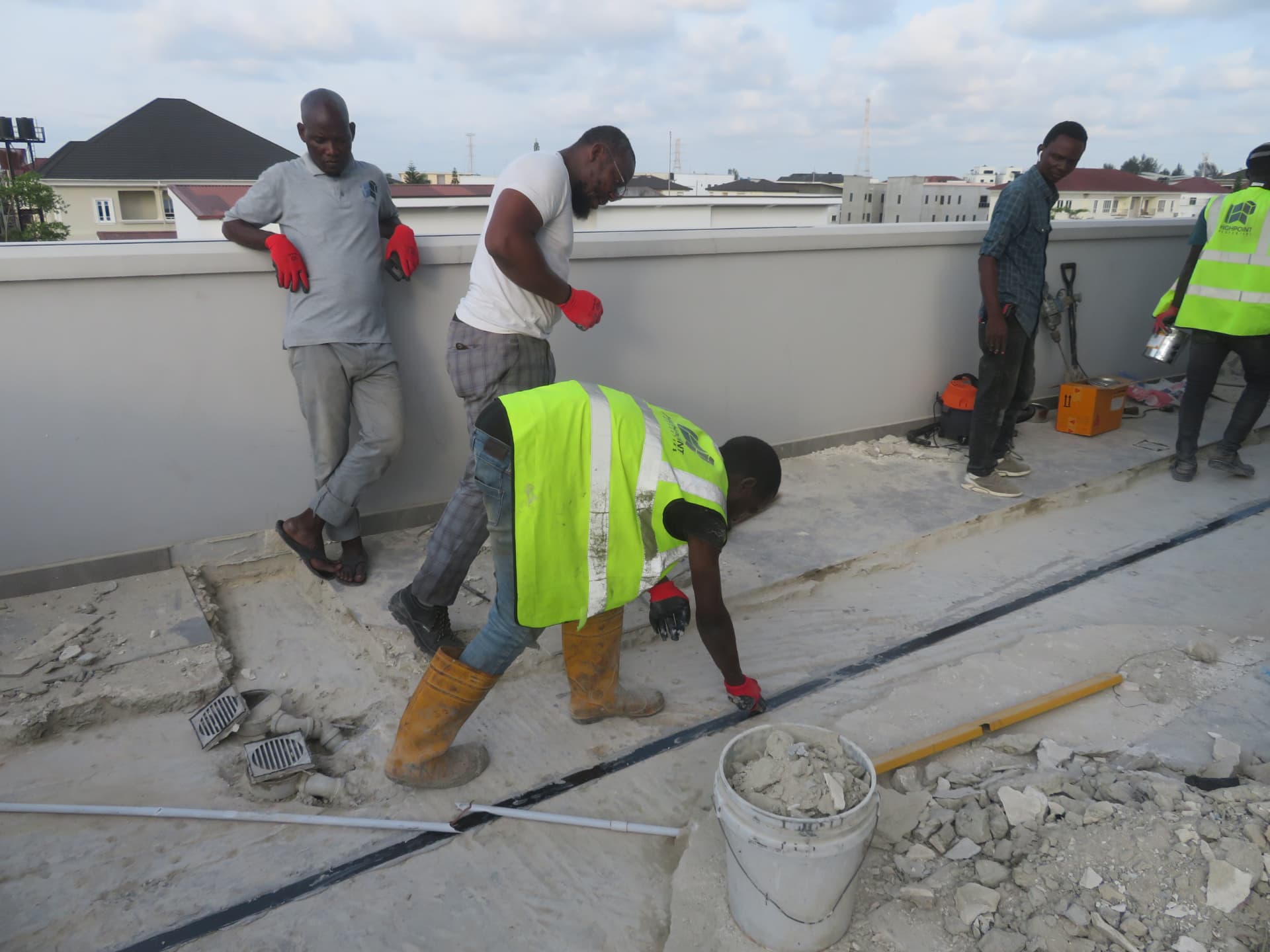 Workers applying epoxy along the cut groove on the roof slab