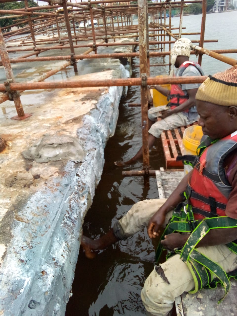 Operatives applying repair mortar along the jetty beam edge