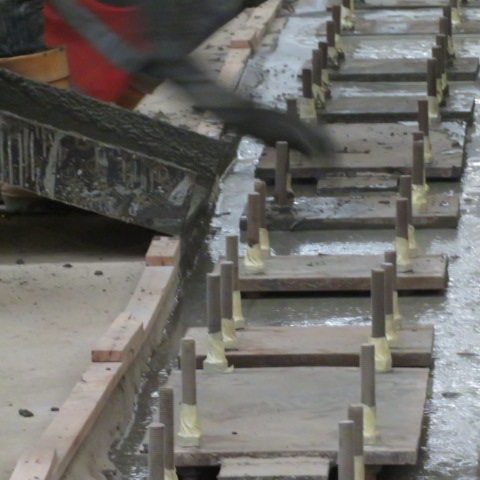 Fresh grout poured into timber-formed base plate pockets