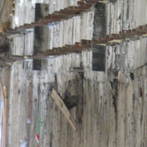 Exposed anchor bolts and starter bars in the stripped rail trench