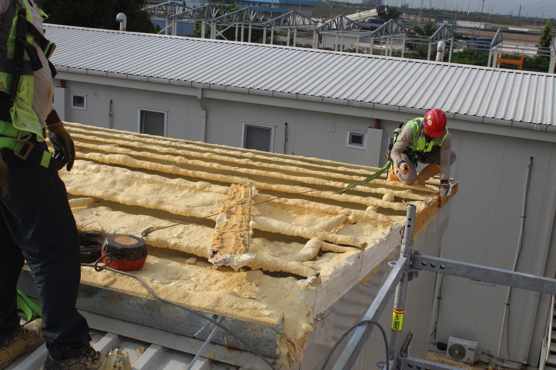Crew securing the roof perimeter above the sprayed insulation