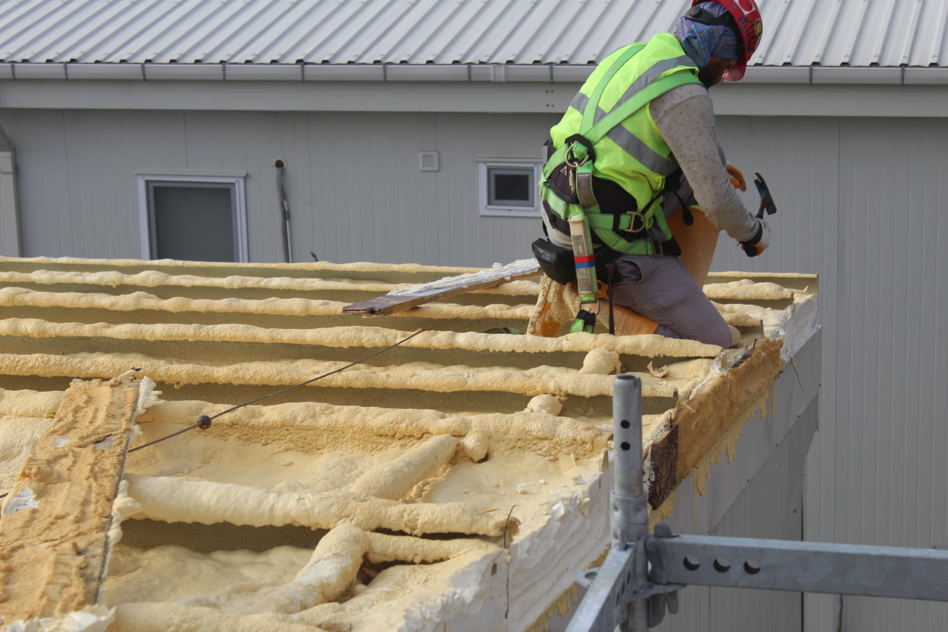 Worker fixing timber battens over the insulated roof edge