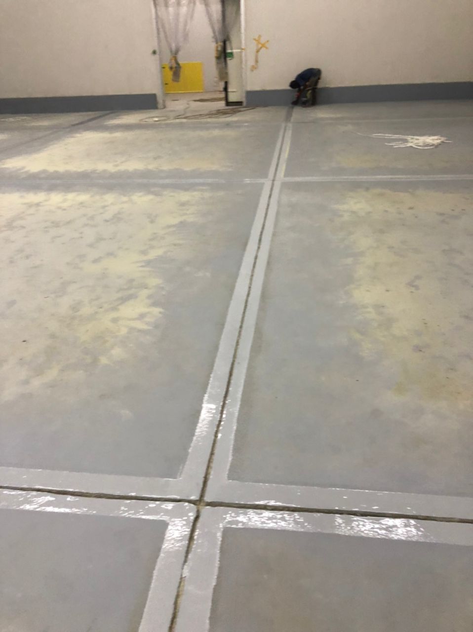 Freshly sealed joint intersection with protective sheeting nearby