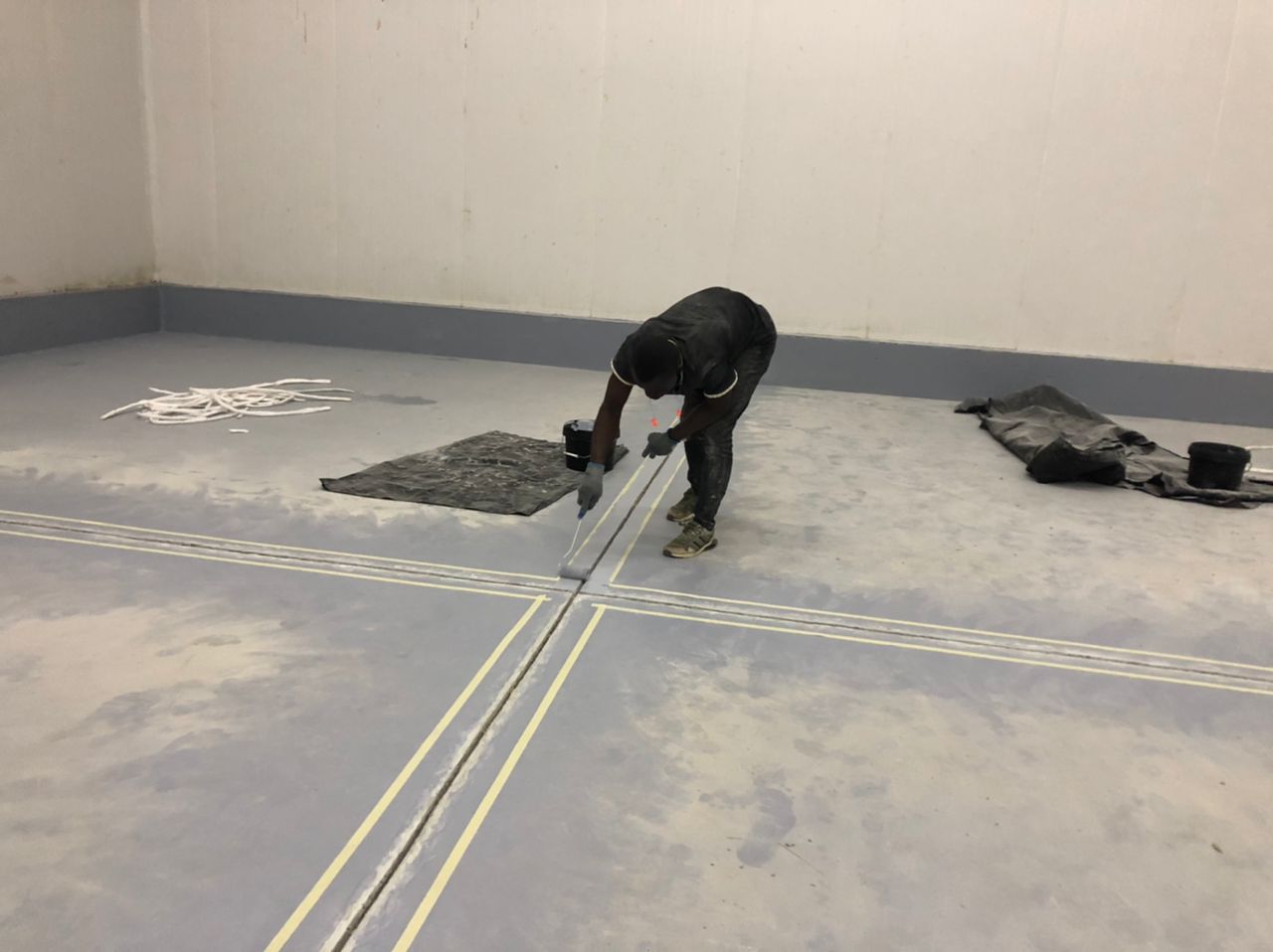 Technician priming the routed joint with a roller